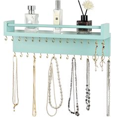 a shelf with several necklaces hanging from it's sides and two bottles on top