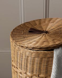 a wicker basket sitting on top of a wooden floor next to a white towel