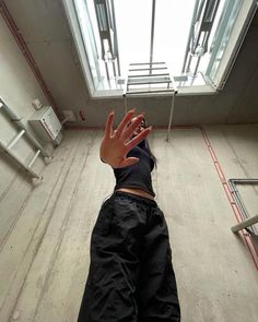 a person reaching up into the air with their hand in front of an open window