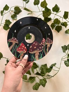 a person holding up a paper plate with mushrooms on it and stars in the sky