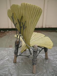 a yellow chair sitting on top of a tarp covered ground