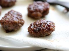 some meatballs sitting on top of a white plate next to a pair of scissors