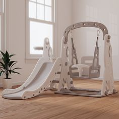 two children's swings and a slide in the middle of a room with hardwood floors