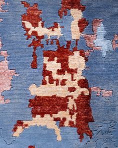 a blue and red area rug with different colored designs on it's edges, including the outline of a map