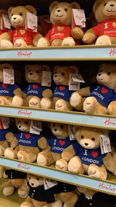 several teddy bears are on display in a toy store, one is wearing a t - shirt and the other has i love london written on it