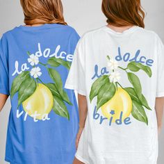 two women wearing matching t - shirts with lemons and flowers on the front, one in blue