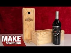 a bottle of wine sitting next to a wooden box with a corkscrew in it