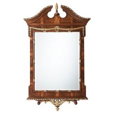 an ornate wooden mirror with gold trimmings on the edges and sides, against a white background