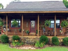 a wooden house with plants on the front porch