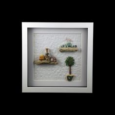 a white frame with three different types of items on it and a small tree in the middle