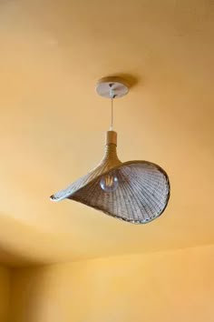 a light fixture hanging from the ceiling in a room with yellow walls and flooring