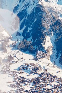 an aerial view of a ski resort in the mountains with snow on the ground and trees around it