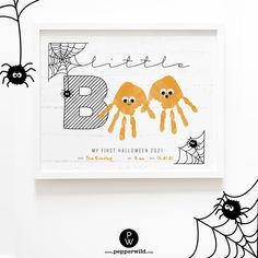 two orange hands are on the front of a white frame with spider webs around it