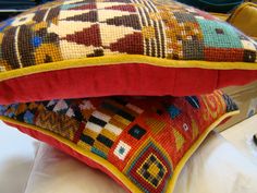 two colorful pillows sitting on top of each other