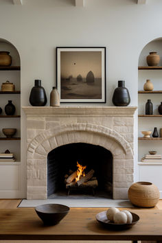 a fireplace in a living room filled with lots of shelves and vases on top of it