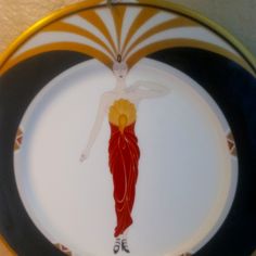 a plate with an image of a woman in red and yellow on it's side