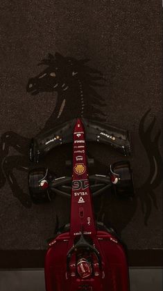 an aerial view of a race car with the shadow of a horse on the ground