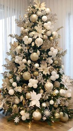 a decorated christmas tree with white and silver ornaments