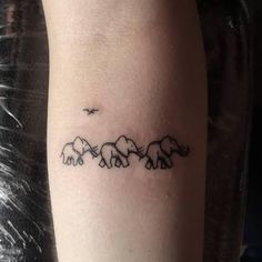 an elephant family tattoo on the left forearm and arm, with three elephants in line