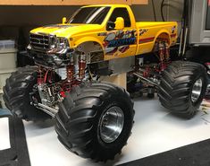 a yellow monster truck with big tires on display