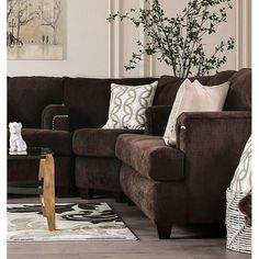 a living room with brown couches and pillows on the floor next to a coffee table