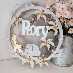 a metal frame with an elephant and giraffe on it next to some flowers