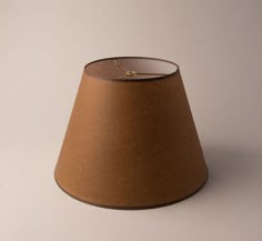 a brown lamp shade sitting on top of a white table