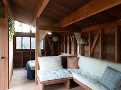 a living room with wood paneling and white pillows on the couch in front of it