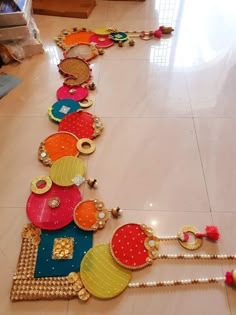 a long row of colorfully decorated items on the floor in a room with white tile floors