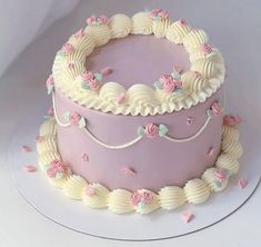 a pink cake with white frosting and flowers on top