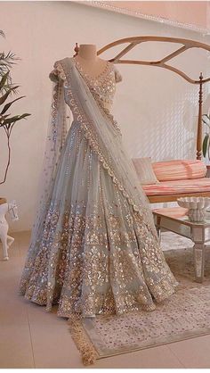 a mannequin is dressed up in a silver lehenga with gold sequins