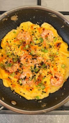 an omelet with shrimp and vegetables in a frying pan