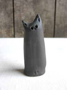 a gray cat figurine sitting on top of a table