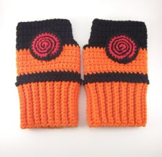 two crocheted orange mittens sitting next to each other