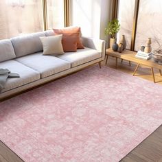 a living room area with a couch, coffee table and large window in the background