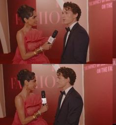 a man in a tuxedo talking to a woman in a red dress and holding a microphone