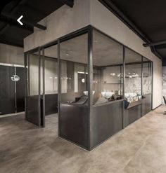 an office with glass walls and lots of furniture