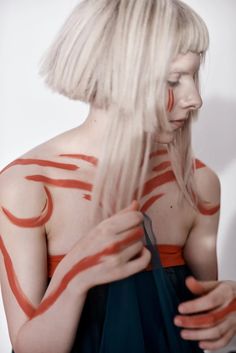 a woman with white hair and red markings on her body