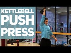 a woman holding a kettle while standing in front of a window with the words kettlebell push press