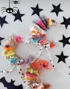 several colorful hair clips are arranged on a white surface with black stars and spider webs