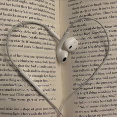 an open book with headphones in the shape of a heart