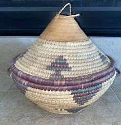 a woven basket sitting on top of a tiled floor