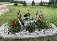 an old wagon with flowers growing out of it in the middle of a garden area