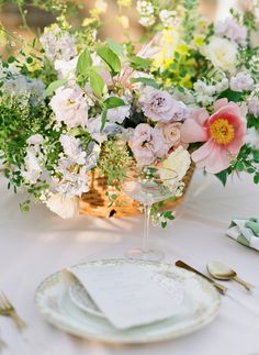 an arrangement of flowers and greenery on a table