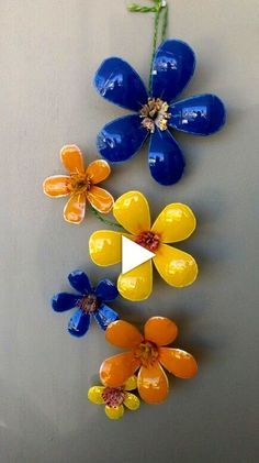 colorful flowers are hanging on the wall in front of a gray background with white and yellow accents