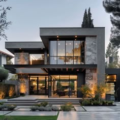 an exterior view of a modern house with large windows and stairs leading to the upper level