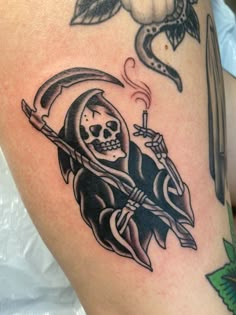 a tattoo with a skeleton holding a knife and a skull on it's arm