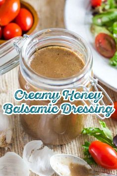 creamy honey balsamic dressing in a glass jar with fresh vegetables and garlic on the side