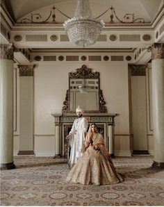 the bride and groom are posing for their wedding photo in front of an ornate chandelier