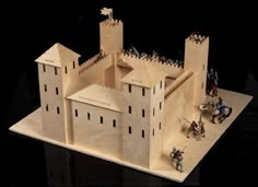 a wooden model of a castle with knights on it